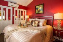 King Bed in Cottage Suite with Red Walls and Rooster Painting